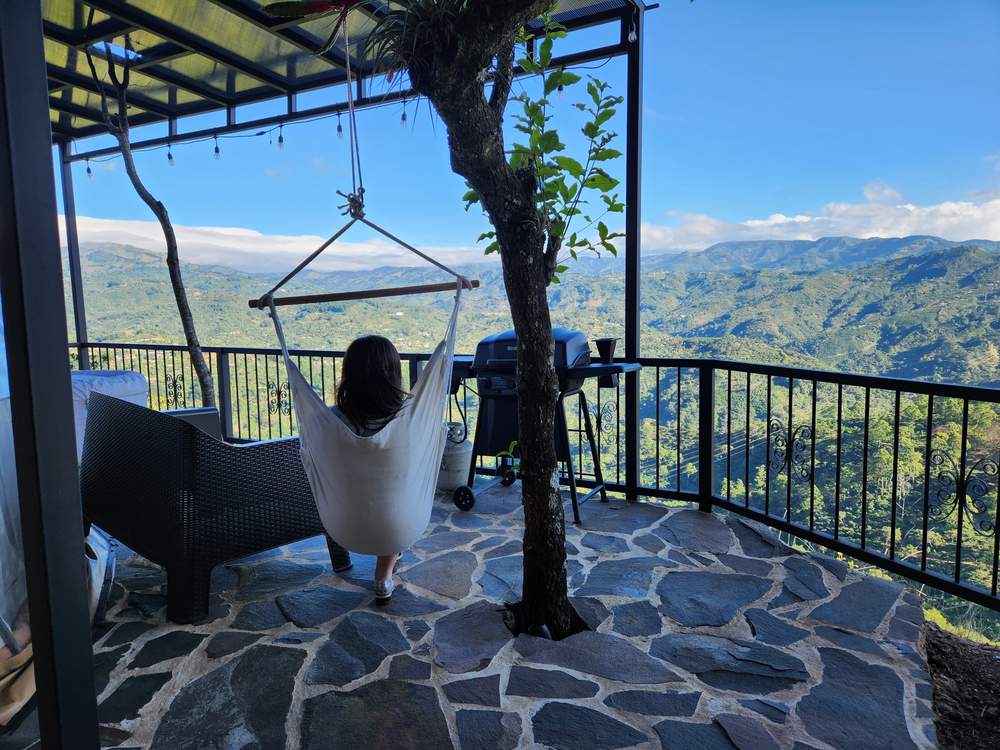 Terraza común con silla hamaca, parrilla y vista abierta al valle
